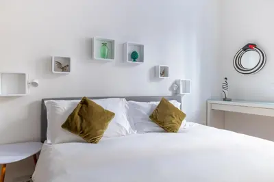 a bedroom with a white bed with two pillows at Urban Chic 2 BR Vatican Escape in Rome