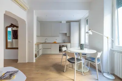 a kitchen and dining room with a table and chairs at Urban Chic 2 BR Vatican Escape in Rome