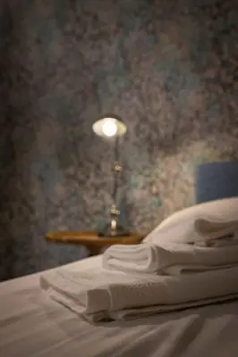 a lamp sitting on a table next to a bed at Merulana Penthouse: 5 minutes WALK from Colosseum in Rome