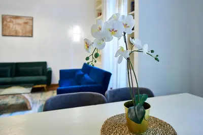 a vase with white flowers sitting on a table at Vatican 2BR Walk to St Peters IREX Apartment in Rome