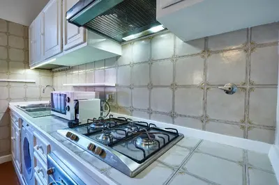 a kitchen with a stove and a counter top at Vatican 2BR Walk to St Peters IREX Apartment in Rome