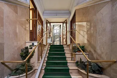 a staircase with green carpeting in a building at Vatican 2BR Walk to St Peters IREX Apartment in Rome