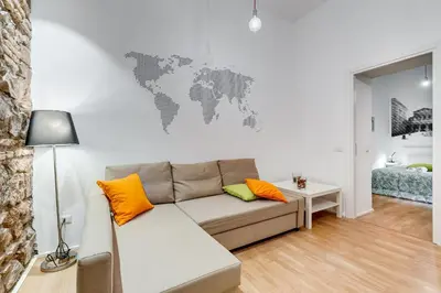 a living room with a couch and a world map on the wall at TRASTEVERE SUITE EXPERIENCE in Rome