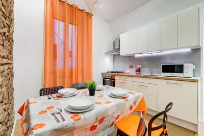 a kitchen with a table and chairs and a dining room at TRASTEVERE SUITE EXPERIENCE in Rome