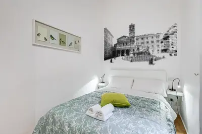 a white bedroom with a bed with towels on it at TRASTEVERE SUITE EXPERIENCE in Rome