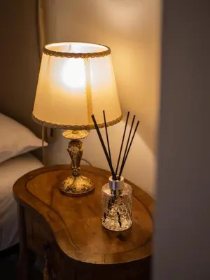 a table with a lamp and a vase with sticks at Minerva House Pantheon in Rome