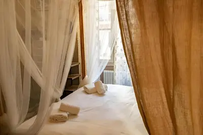 a bedroom with white curtains and towels on a bed at Lucky Jazz BuddyRent in Rome
