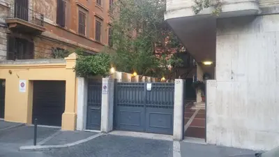 a garage with a blue gate in front of a building at Charming Apartment Piazza del Popolo in Rome
