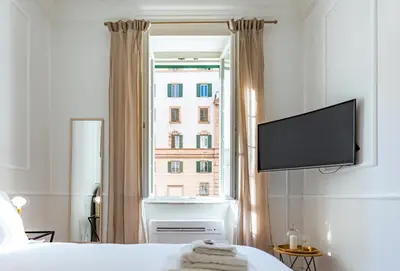 a bedroom with a window with a flat screen tv at Giò House - Palazzo Storico in Rome