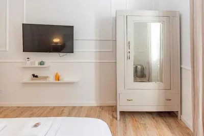 a bedroom with a white cabinet and a tv at Giò House - Palazzo Storico in Rome