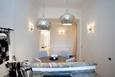 a kitchen with a table and two pendant lights at Giò House - Palazzo Storico in Rome