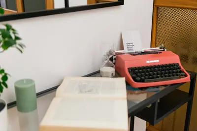a red typewriter sitting on a desk with a book at Appartamento via di Porta Labicana in Rome