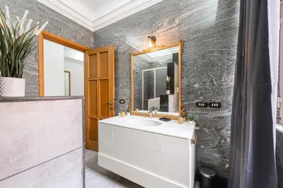 a bathroom with a white sink and a mirror at Appartamento via di Porta Labicana in Rome