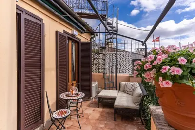 a balcony with chairs and a table and flowers at Twilight Terrace - Piazza di Spagna in Rome