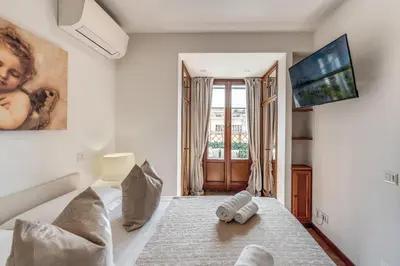 a bedroom with a bed and a tv on a wall at Twilight Terrace - Piazza di Spagna in Rome