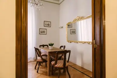 a dining room with a table and chairs and a mirror at Appartamento Roma Vaticano 