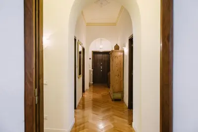 a hallway with white walls and wooden floors at Appartamento Roma Vaticano 