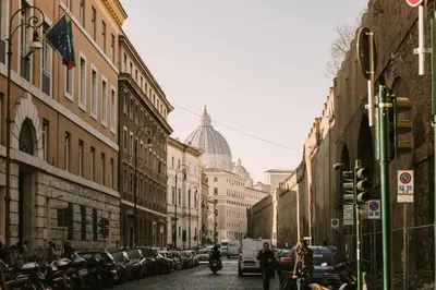 a city street with buildings and cars and a dome at Appartamento Roma Vaticano 