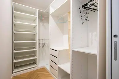 a white walk in closet with white shelves at Testaccio Boutique Apartment in Rome