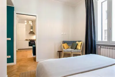 a bedroom with a bed and a chair in a room at Testaccio Boutique Apartment in Rome