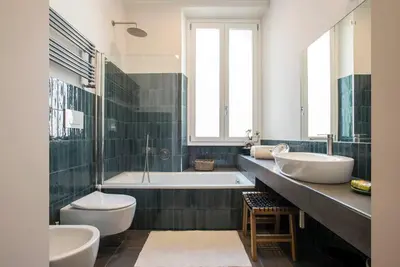 a bathroom with two sinks and a tub and two toilets at Testaccio Boutique Apartment in Rome