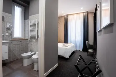 a bathroom with a bed and a toilet and a sink at SABA SUITE ROMA in Rome