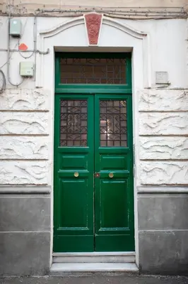 a green door on a white building with a window at SABA SUITE ROMA in Rome