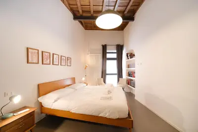 a bedroom with a bed and a desk and a lamp at Golden House BuddyRent in Rome