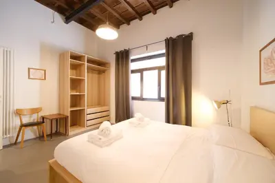 a bedroom with a large white bed and a window at Golden House BuddyRent in Rome