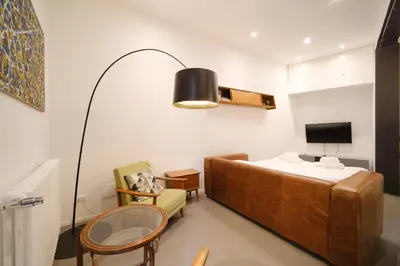 a room with a bed and a chair and a tv at Golden House BuddyRent in Rome