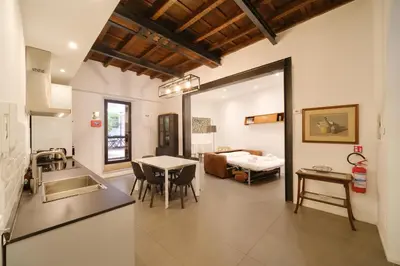 a kitchen and living room with a table and a bed at Golden House BuddyRent in Rome