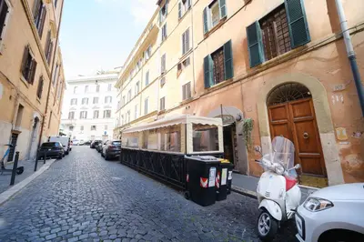 a scooter parked on a street next to a building at Golden House BuddyRent in Rome