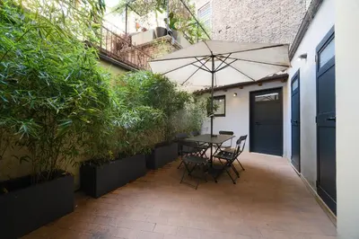 a patio with an umbrella and a table and chairs at Golden House BuddyRent in Rome