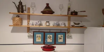 a kitchen with wooden shelves and pictures on the wall at Romeo. Luminoso appartamento al centro di Roma in Rome