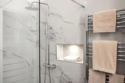 a bathroom with a shower and a mirror and towels at Casa Matteo53, Termini in Rome