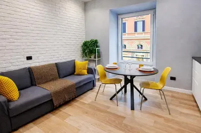 a living room with a couch and a table with yellow chairs at Simona's Vatican in Rome