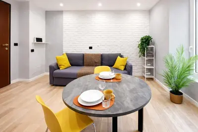 a living room with a table and yellow chairs at Simona's Vatican in Rome