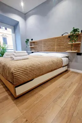 a bedroom with a large bed with a wooden headboard at Simona's Vatican in Rome