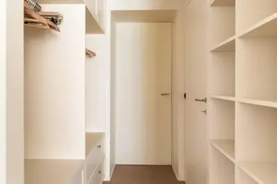 a white walk in closet with a door and shelves at Trastevere Luxury Home in Rome