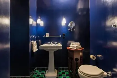 a blue bathroom with a toilet and a sink at Trastevere Luxury Home in Rome