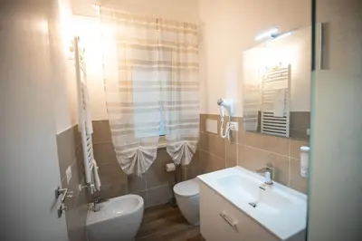a bathroom with a sink and a toilet at ROMECOMING Ostiense Guest House in Rome