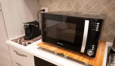 a microwave oven on a counter in a kitchen at ROMECOMING Ostiense Guest House in Rome