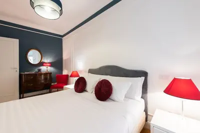 a bedroom with a white bed with red pillows at Germanico Charming Maison in Rome