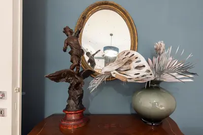 a mirror on top of a table next to a vase at Germanico Charming Maison in Rome
