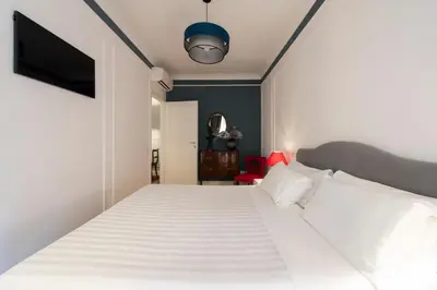 a bedroom with a white bed and a tv at Germanico Charming Maison in Rome