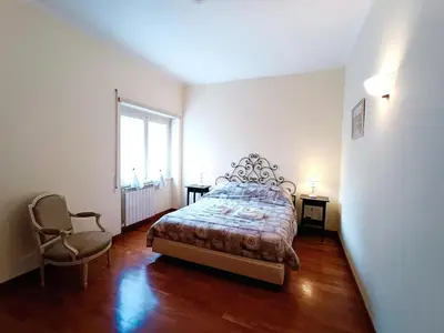 a bedroom with a bed and a chair and a window at Appartamento per le tue vacanze a Roma Villa Pamphili in Rome