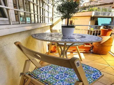 a table and a chair with a potted plant on a balcony at Appartamento per le tue vacanze a Roma Villa Pamphili in Rome