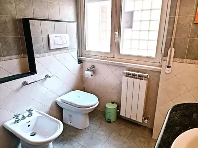 a bathroom with a sink and a toilet and a window at Appartamento per le tue vacanze a Roma Villa Pamphili in Rome