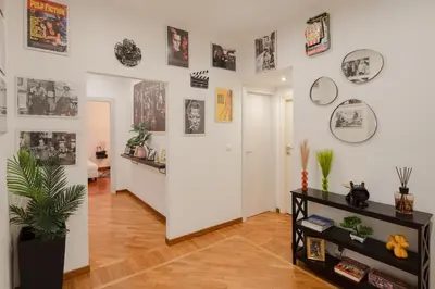 a living room with a white wall with pictures on it at Pop Corn Vatican Suites in Rome
