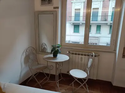 a small table and two chairs in a room with a window at Pop Corn Vatican Suites in Rome